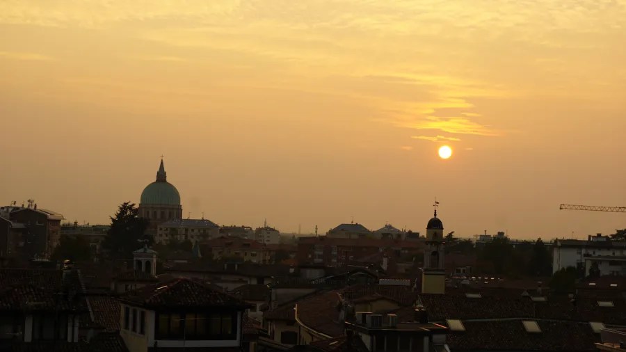 20221015_2_Italien_Udine (41) City skyline featuring a large dome silhouetted against a hazy golden sunset