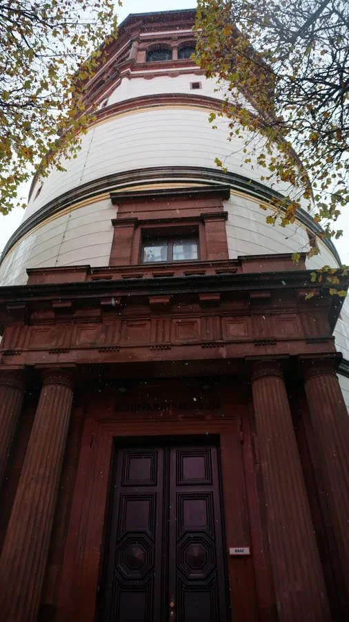 Entrance to the Schifffahrtsmuseum, a white tower with dark stone columns, labeled 'SCHIFFAHRT-MUSEUM' and 'BMZ'.