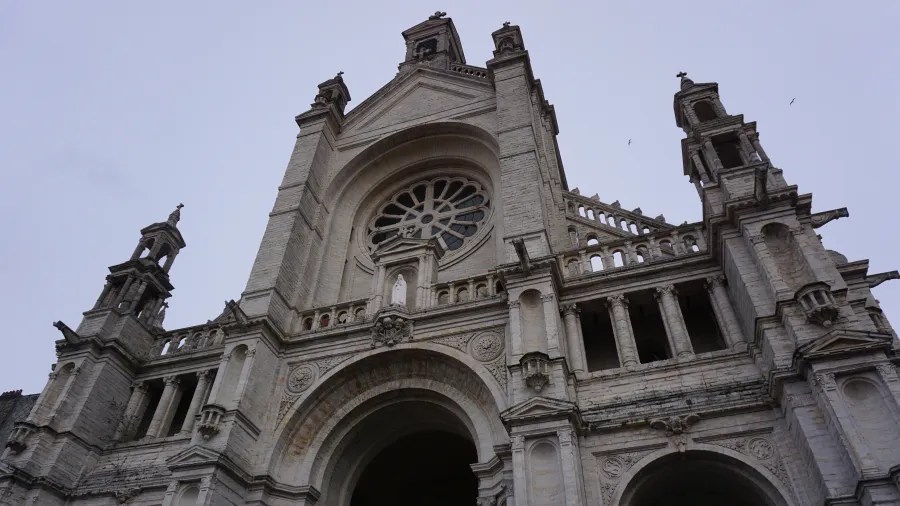 Low-angle view of an ornate stone cathedral facade with a large rose window.
