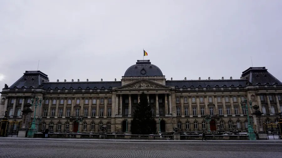 The Royal Palace of Brussels with a large Christmas tree in front under an overcast sky