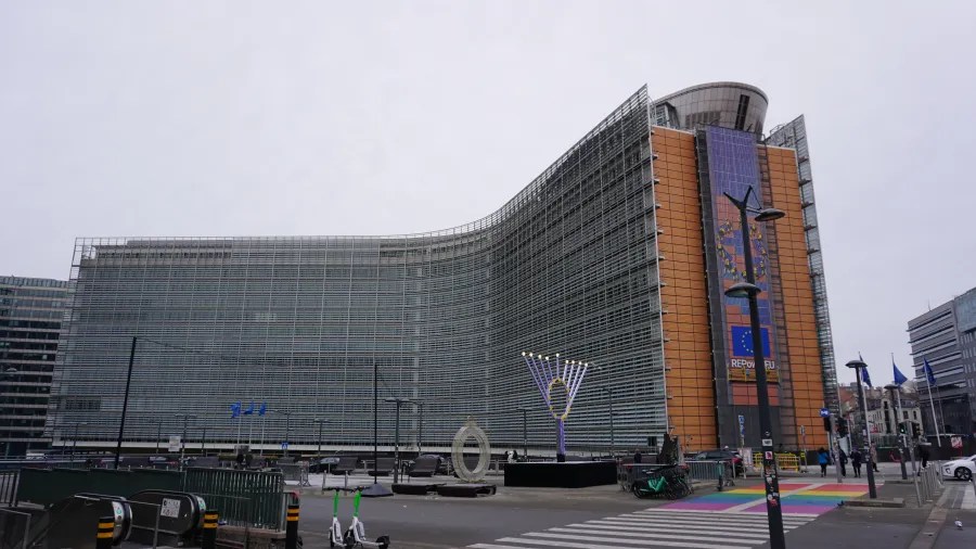 The Berlaymont building in Brussels with a REPowerEU banner and a large Hanukkah menorah outside.