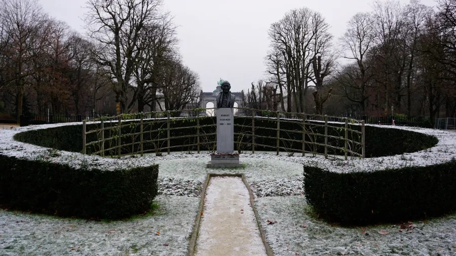 Bust of Robert Schuman inscribed 'ROBERT SCHUMAN 1886 - 1963' in a snow-covered park.