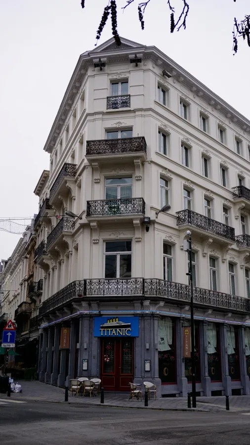 Ornate white corner building with a blue sign reading TITANIC above the entrance.
