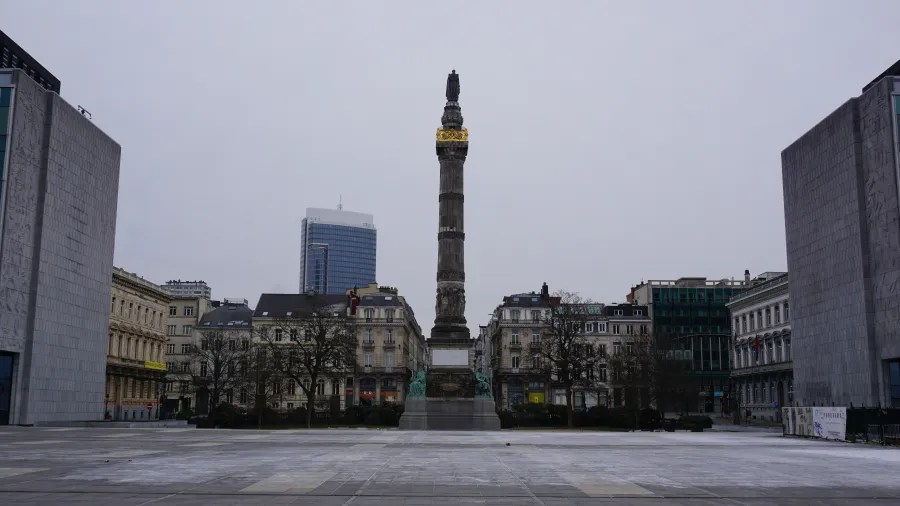 The Congress Column monument in Brussels stands centered in a city square under a grey sky.