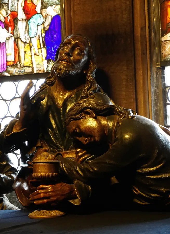 Religious sculpture showing John the Apostle leaning on Jesus, who holds a chalice.