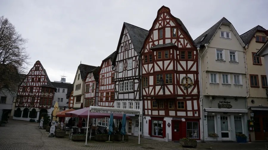 Traditional half-timbered buildings in a square with outdoor seating for Cafe Zum Schlörje Restaurant.