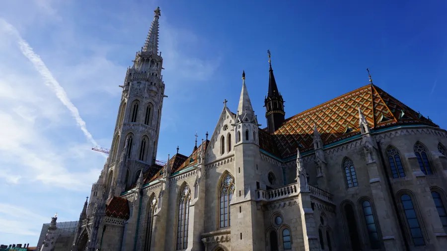 Matthias Church in Budapest with an ornate white spire and vibrant, patterned tile roof