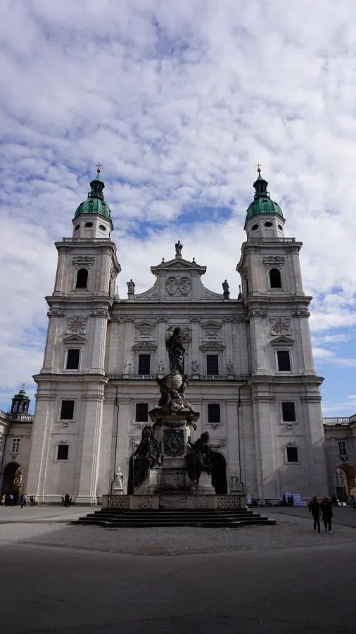 Salzburg Cathedral with its twin green-domed towers and the Marian Column monument.