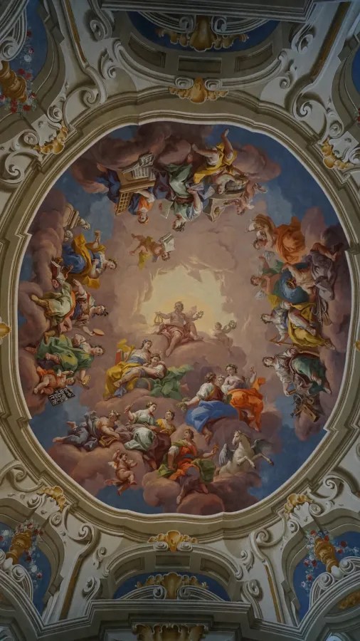 Oval ceiling fresco depicting allegorical figures and cherubs floating among clouds within an ornate frame