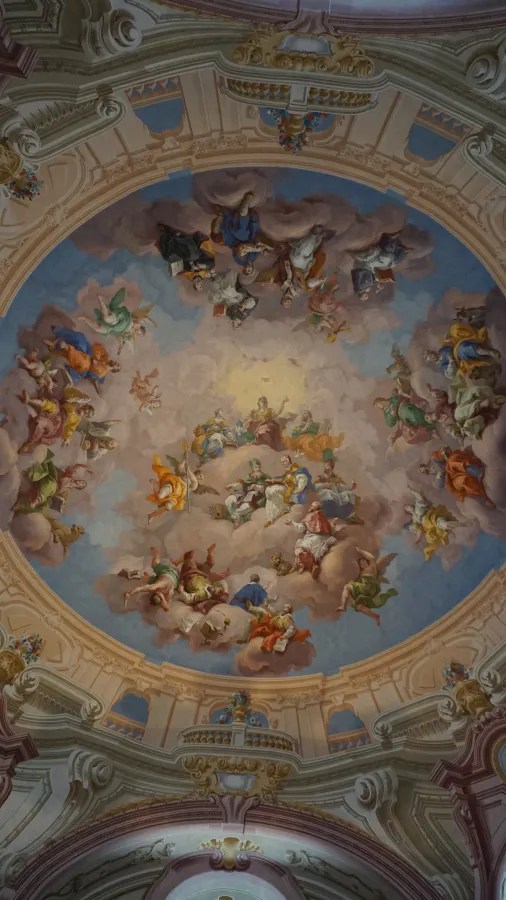 Ornate domed ceiling with a central fresco depicting religious figures among clouds and sky.