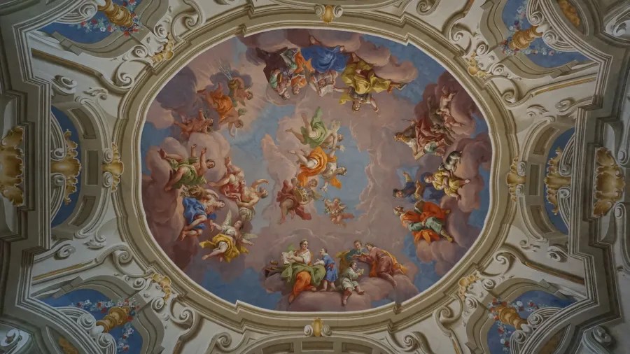 Ornate oval ceiling fresco depicting classical figures and angels among clouds in a blue sky