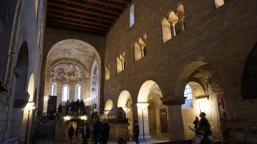 20221021_Tschechien_Prag (137) Ancient stone church interior with vaulted arches, frescoes, and visitors walking through the space.