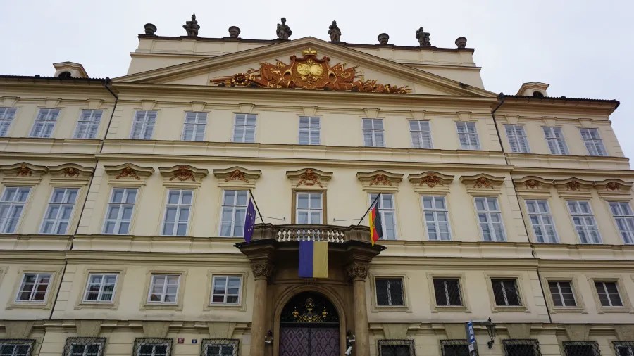 20221021_Tschechien_Prag (169) Ornate building with European Union, Ukrainian, and German flags hanging from a central balcony.