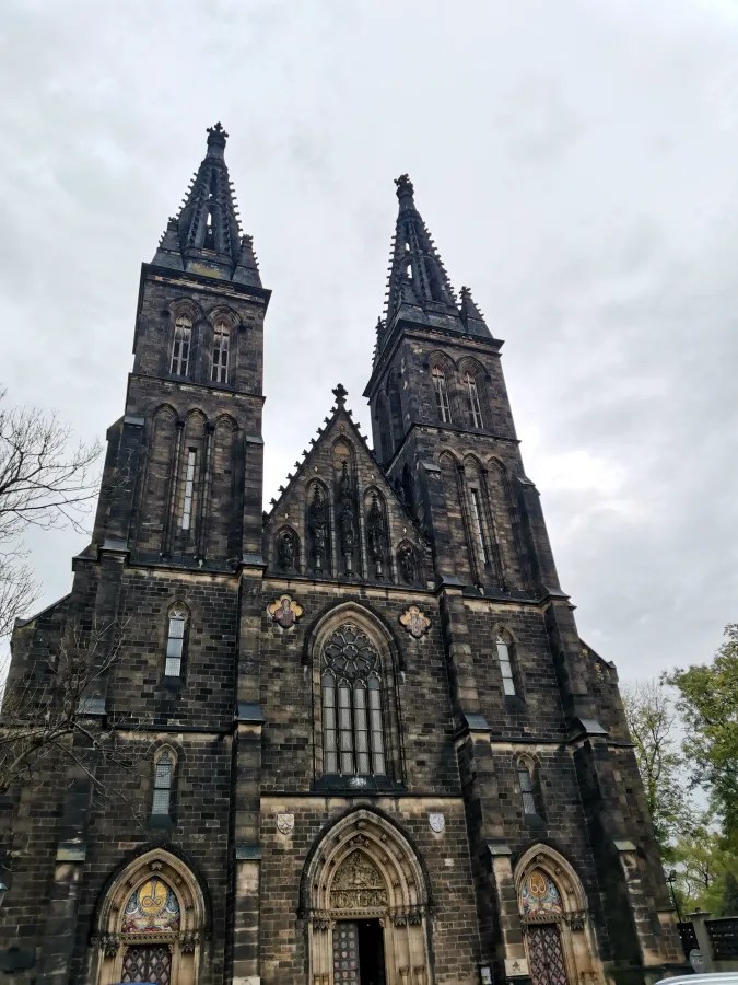 20221021_Tschechien_Prag (219) Dark stone neo-Gothic basilica with two tall spires under an overcast sky