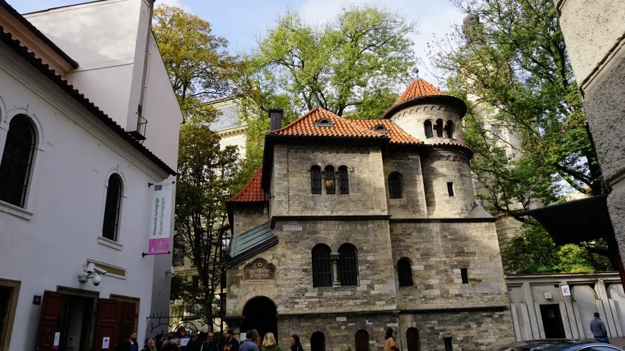 20221021_Tschechien_Prag (58) Stone Ceremonial Hall with a circular tower in Prague, next to a banner for Klausen Synagogue.
