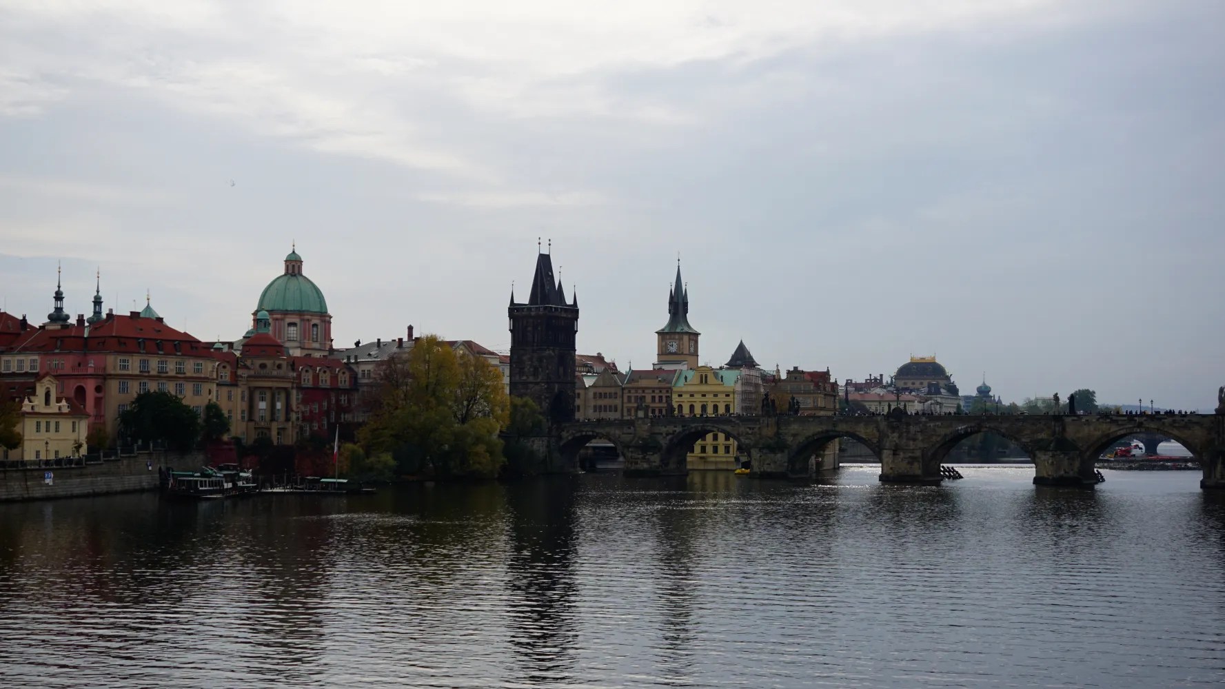The Charles Bridge spanning the Vltava River with the historic Prague skyline in the background
