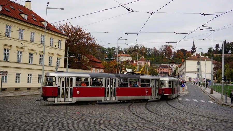 Red and silver tram number 22 turning on a cobblestone street surrounded by historic architecture.
