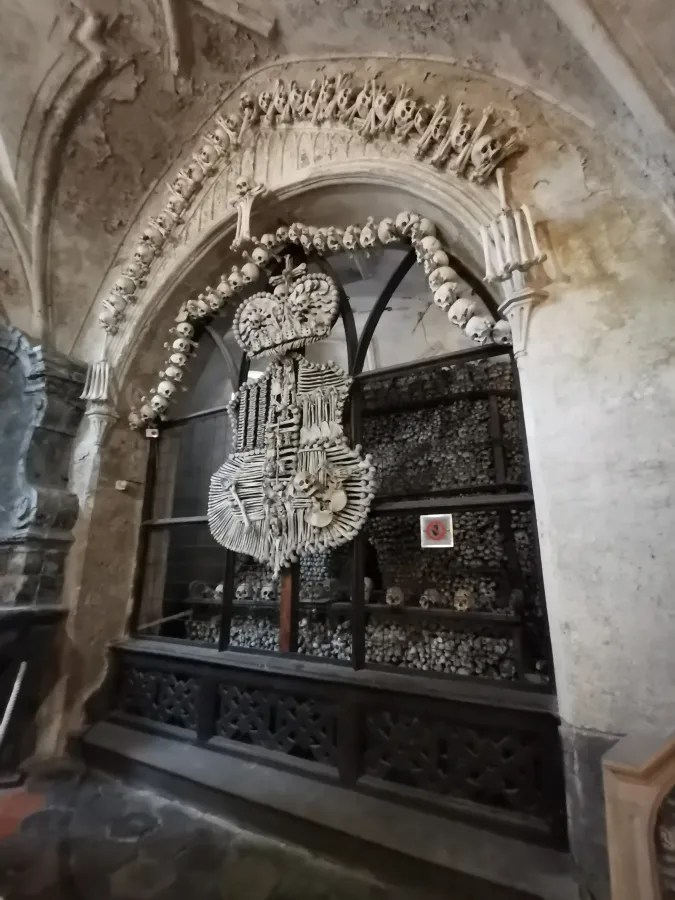 A coat of arms and decorations crafted from human bones inside an ossuary.