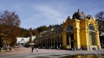 Ornate yellow Neo-Baroque colonnade in Mariánské Lázně under a clear blue sky