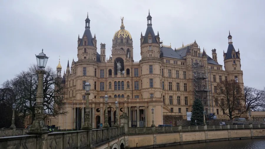 Schwerin Castle featuring multiple ornate towers and a decorative bridge in the foreground.