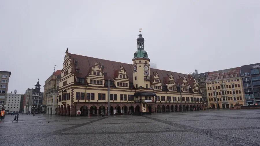 The historic Old City Hall in Leipzig, Germany, bordering a large cobblestone market square.