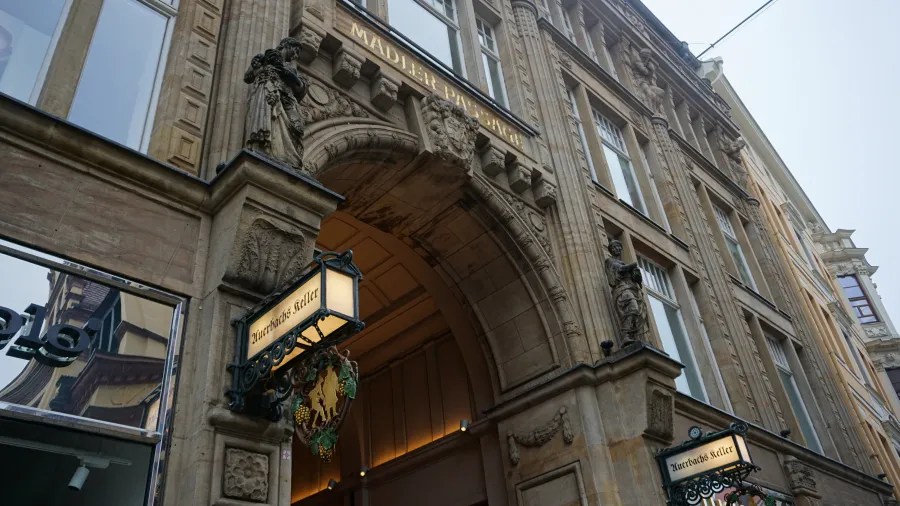 Ornate stone archway entrance to the Mädler Passage featuring signs for Auerbachs Keller.