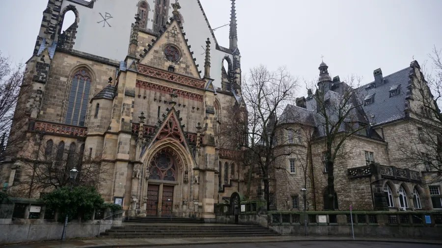 The stone facade and ornate gothic entrance of St. Thomas Church in Leipzig.