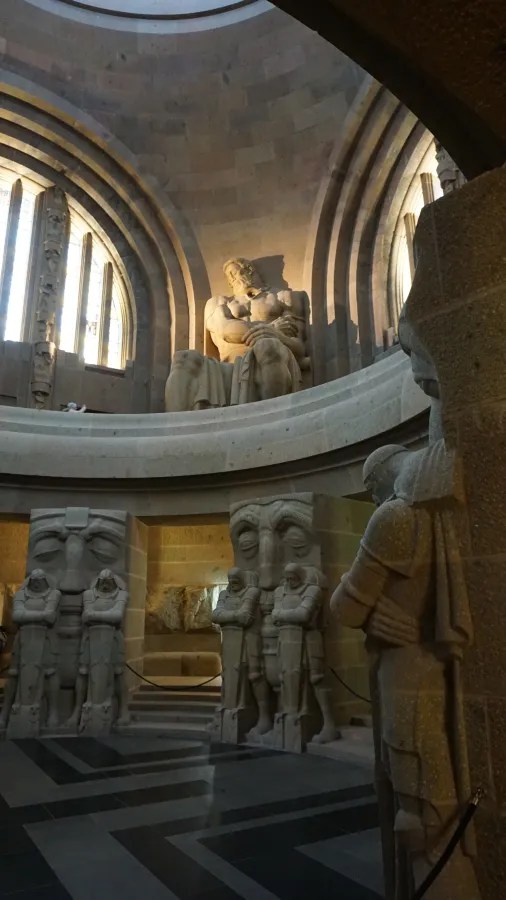 Interior of the Völkerschlachtdenkmal in Leipzig with large stone statues of seated figures and guardians