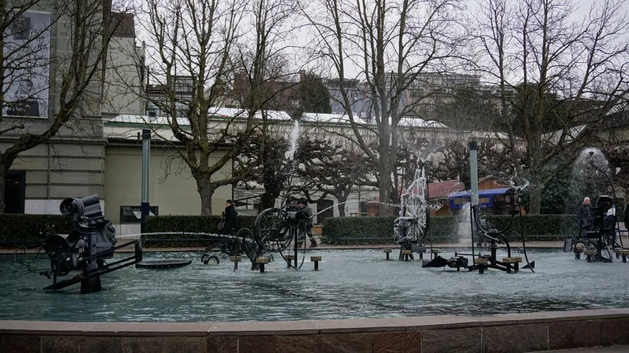 Tinguely Fountain in Basel featuring kinetic metal sculptures spraying water into a large pool.