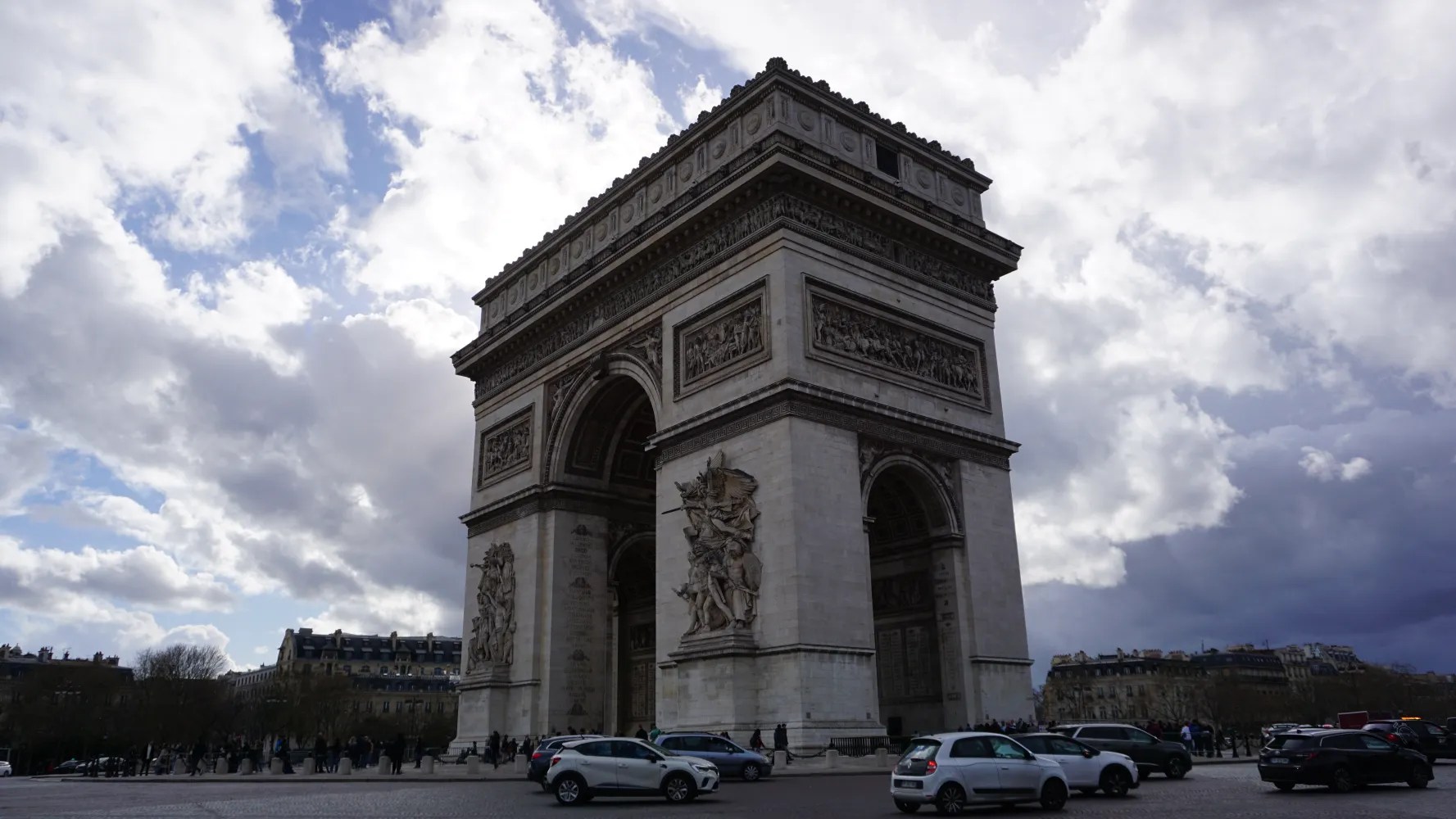 20230324_Frankreich_Paris (153) Arc de Triomphe monument in Paris under a partly cloudy sky with cars and people around