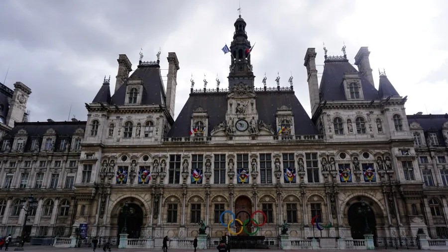 20230324_Frankreich_Paris (34) Historic building facade decorated with Olympic rings and flags under a cloudy sky