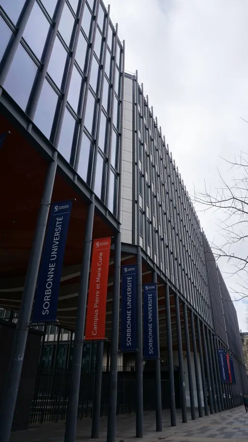 20230324_Frankreich_Paris (53) Tall modern building with vertical metal columns and banners reading Sorbonne Université and Campus Pierre et Marie Curie