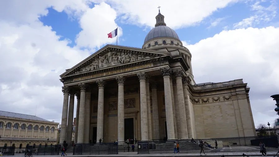 20230324_Frankreich_Paris (73) The Pantheon in Paris with Corinthian columns, a triangular pediment, and a dome topped by a cross under a partly cloudy sky