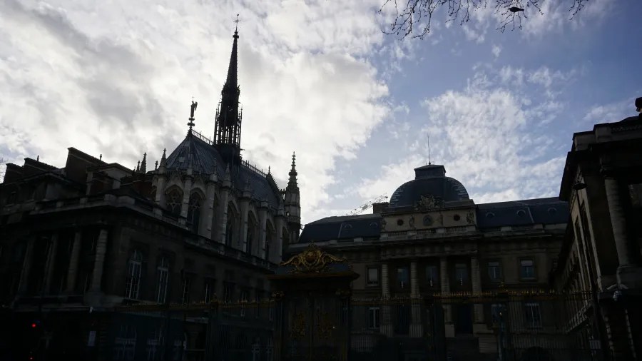 20230325_Frankreich_Paris (206) Historic Gothic-style building with tall spire and ornate architectural details against a partly cloudy sky