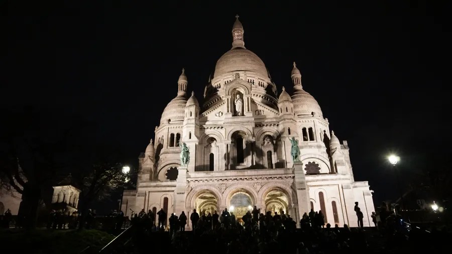20230325_Frankreich_Paris (266) Basilica of Sacré-Cœur illuminated at night with people gathered in front
