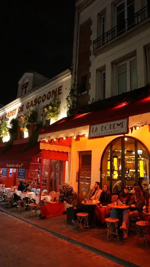 20230325_Frankreich_Paris (283) Outdoor seating area of La Boheme Montmartre restaurant at night with people dining