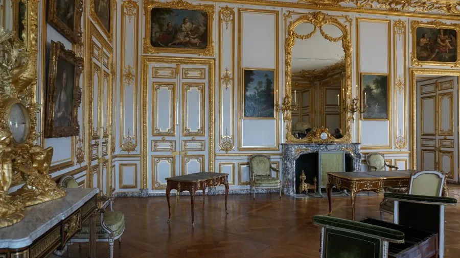20230325_Frankreich_Paris (55) Luxuriously decorated room with gold detailing, antique furniture, and ornate fireplace mirror