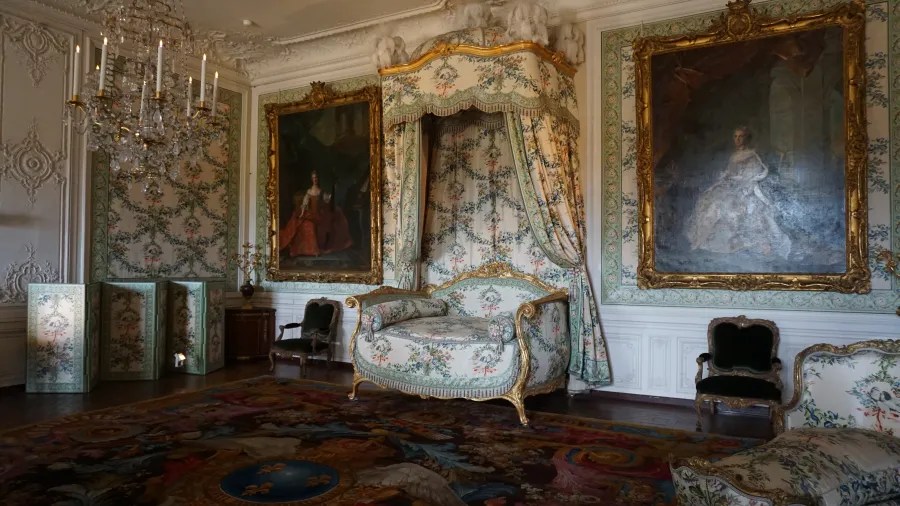 20230325_Frankreich_Paris (59) Luxuriously decorated historical room with floral patterned furniture, ornate chandelier, and large framed portraits