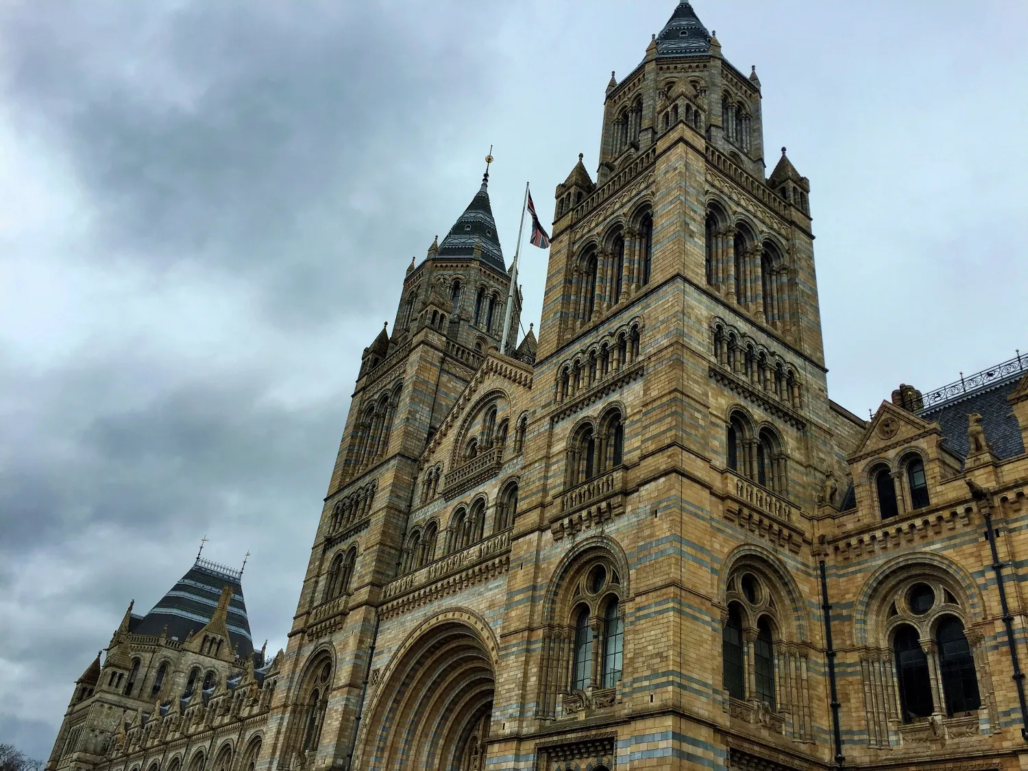 Historic stone building with two tall towers and Union Jack flag