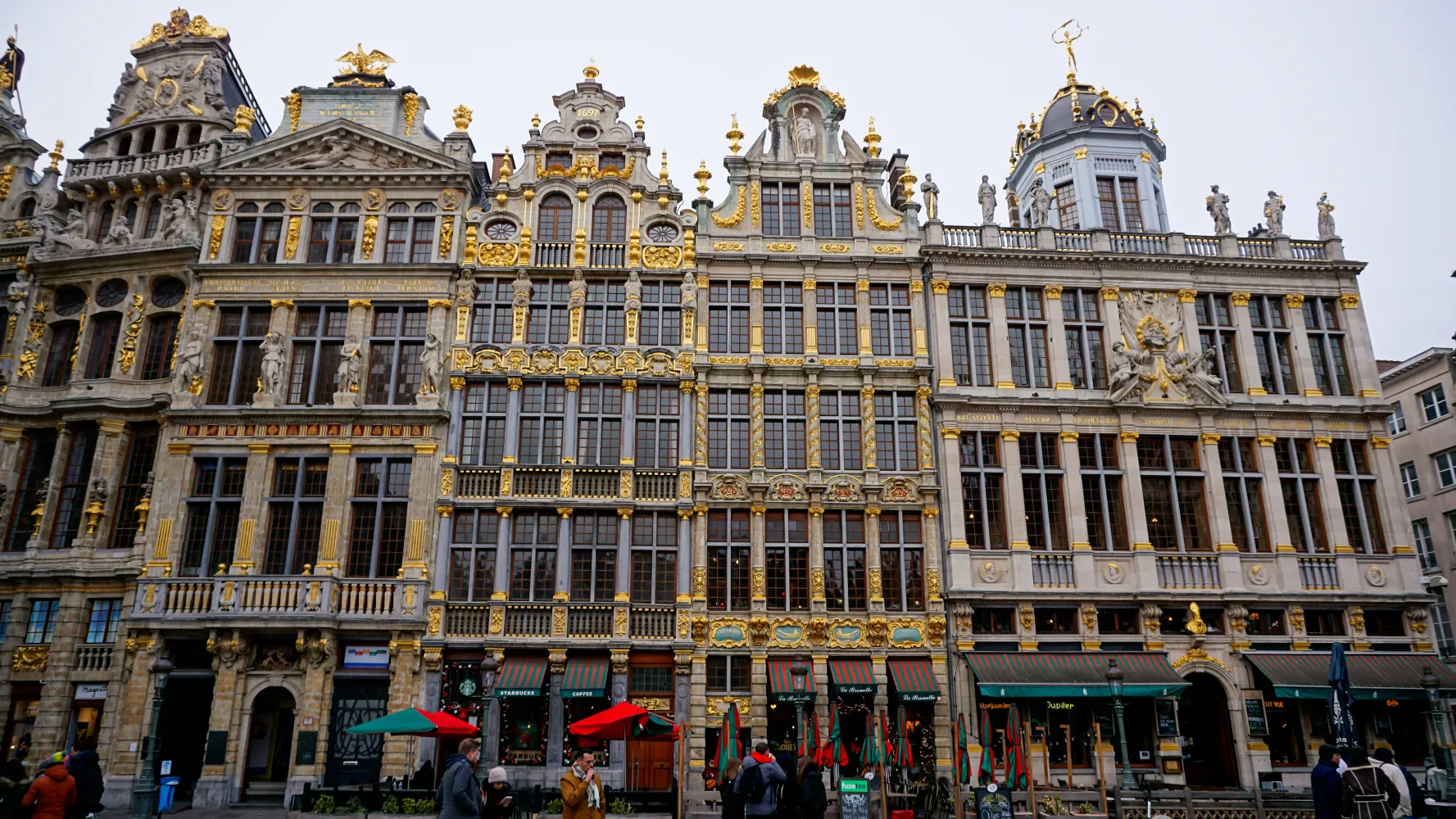Row of ornate historic guildhall buildings with gold decorations and statues in Brussels